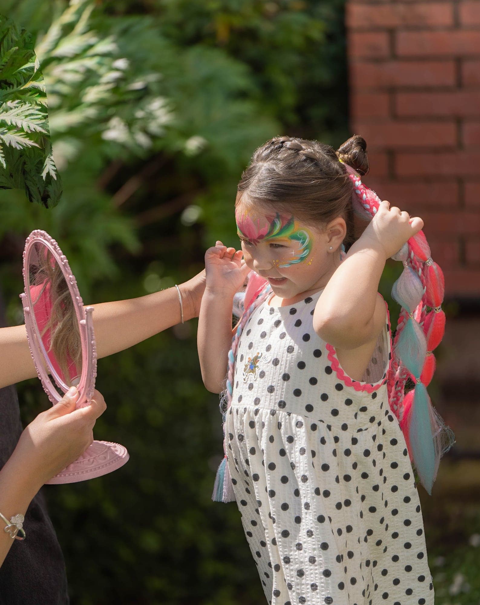 Niña se mira en un espejo después del maquillaje de fantasía