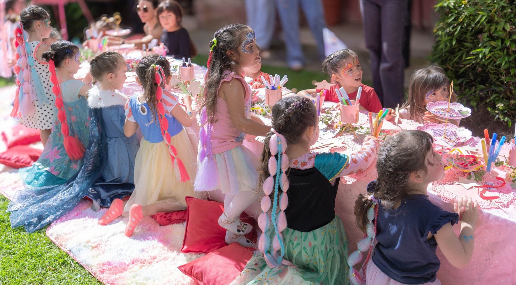 Niñas disfrazadas de princesas comparten en la mesa del cumpleaños