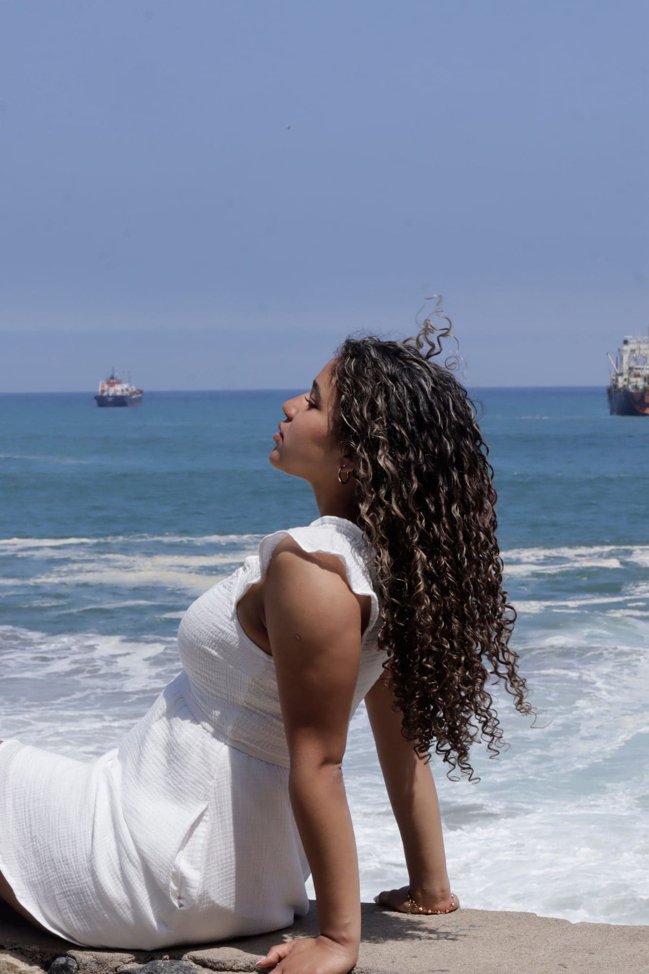 Julieta sentada en las rocas frente al mar