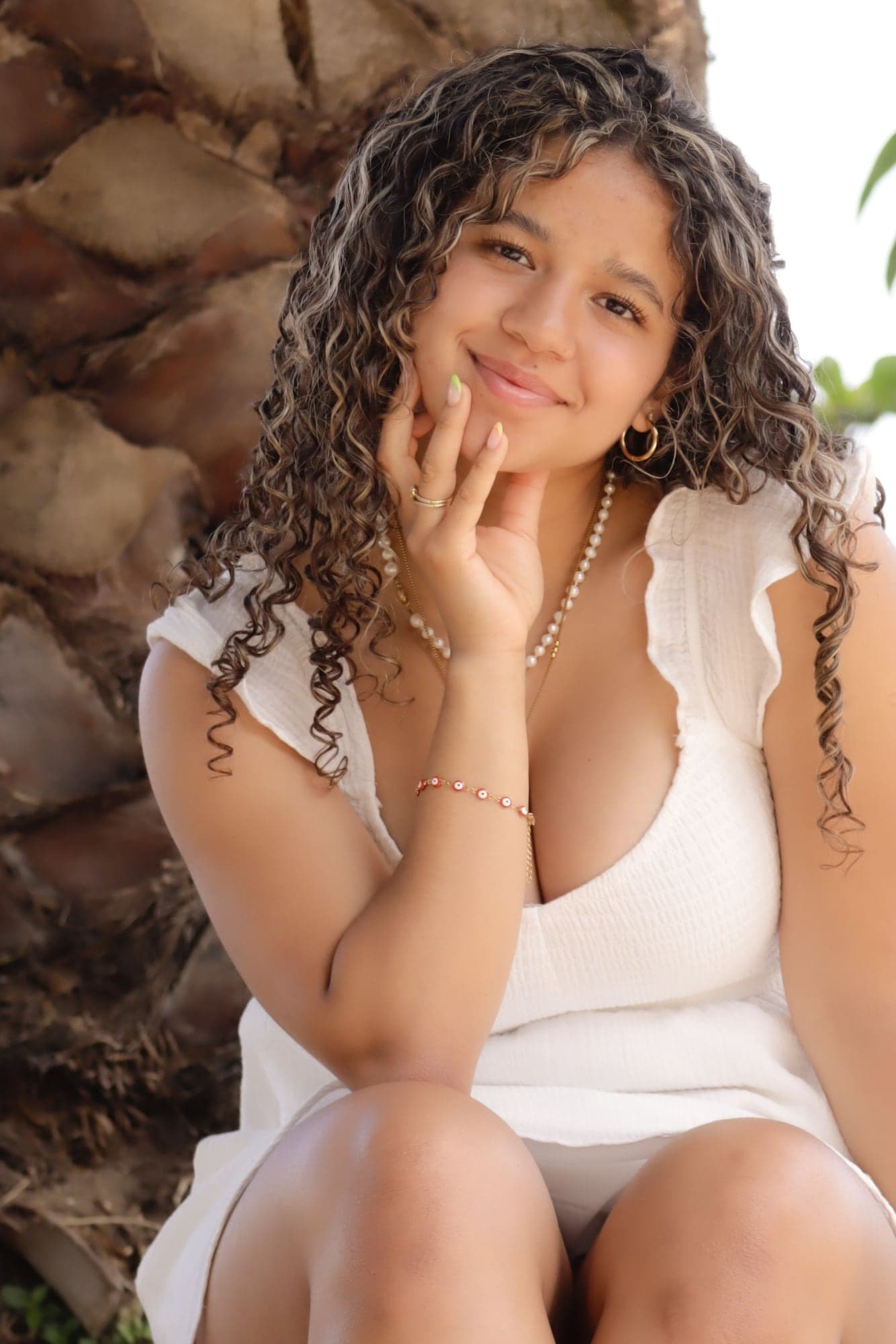 Julieta sonríe sentada, con la mano en el mentón