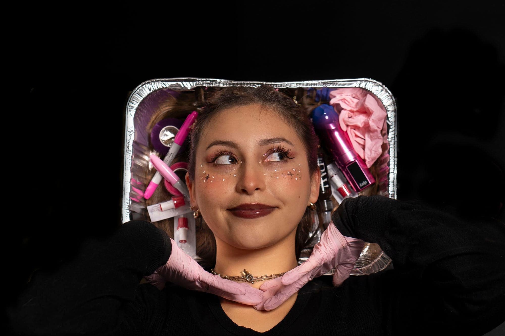 Retrato creativo con maquillaje artístico sobre una bandeja con insumos de tatuaje