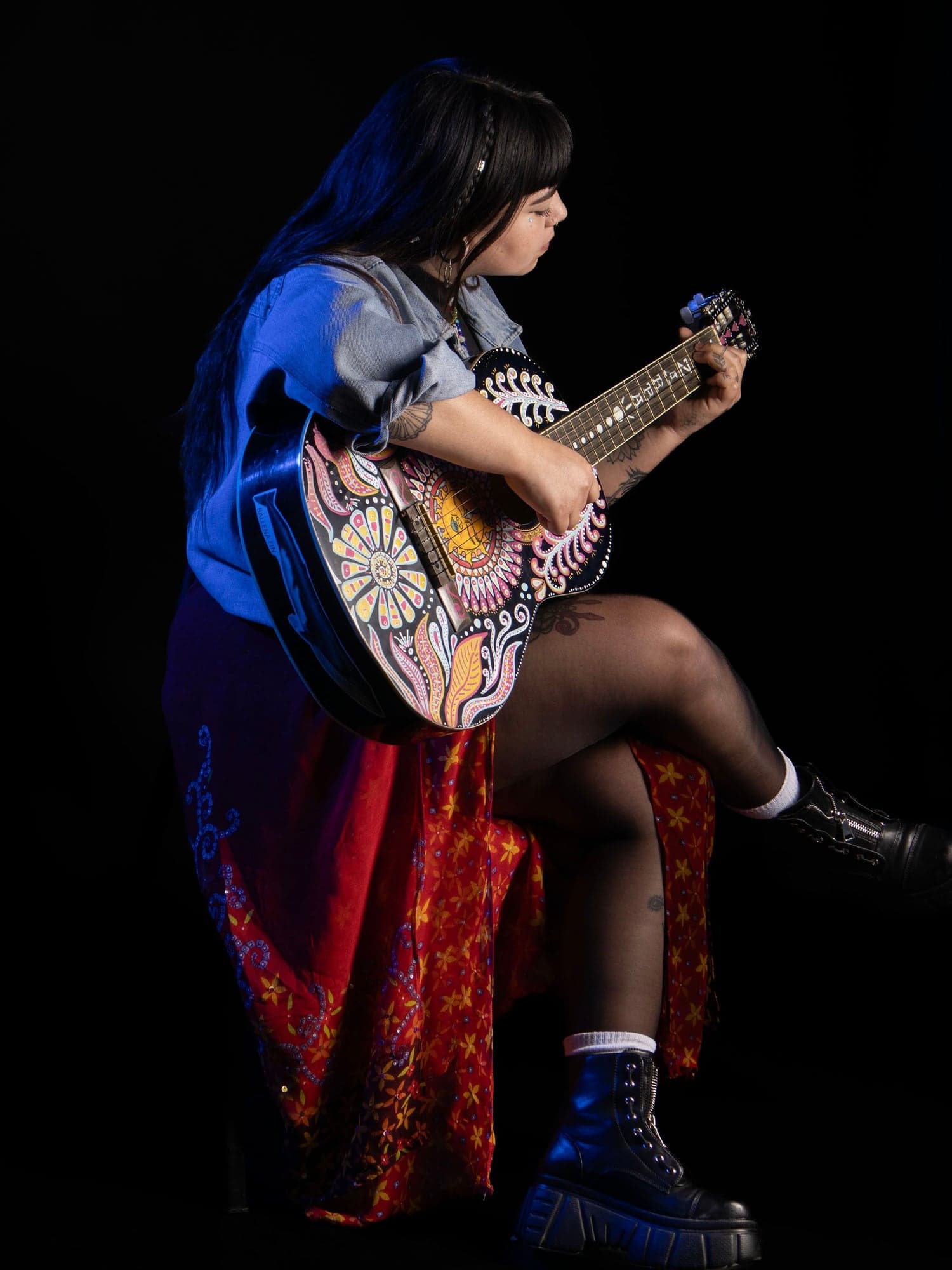 Vai toca su guitarra pintada, de perfil
