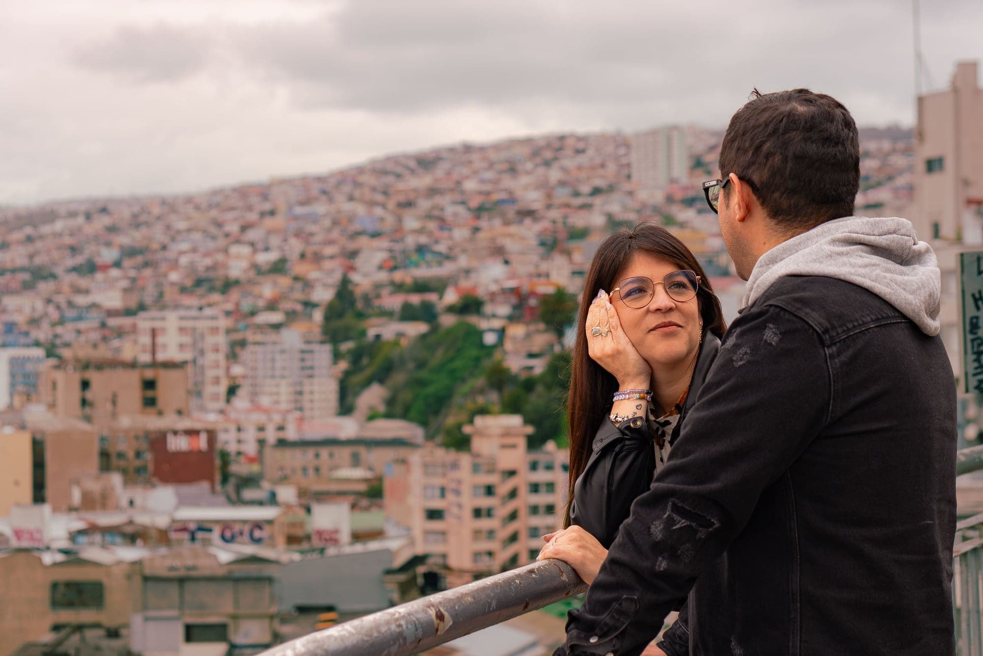 La pareja conversa en un mirador con vista a los cerros